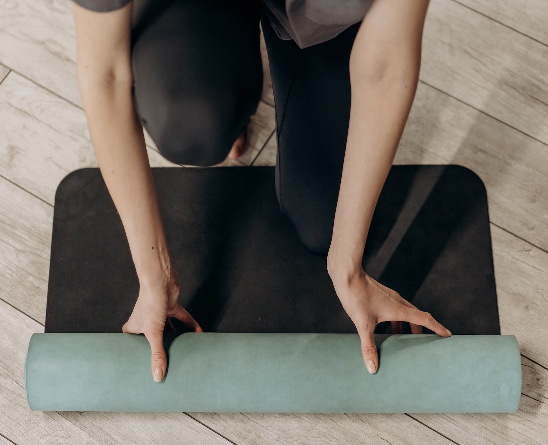 Opening a rolled up yoga mat on the floor