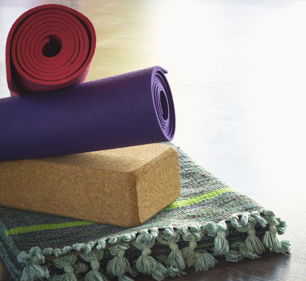 Yoga props, including 2 yoga mats, a block, and a blanket for additional support