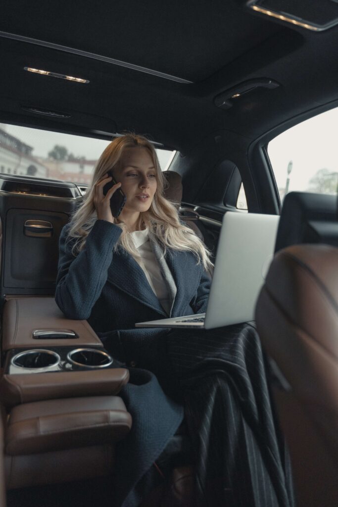 A business woman works on her laptop while in the car representing the fast paced lifestyle that can lead to burnout. Learn to set boundaries with Anxiety Therapy for Women in Manhattan, NY and find balance again.