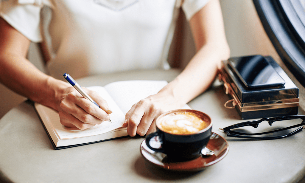 Woman journaling with a coffee cup