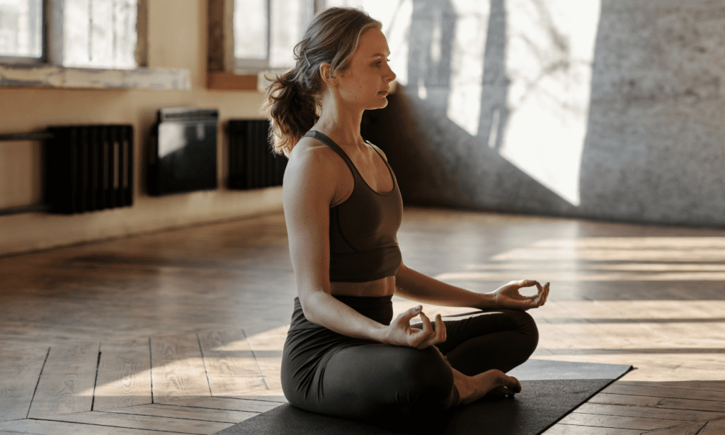Woman meditating on a yoga mat after exercising