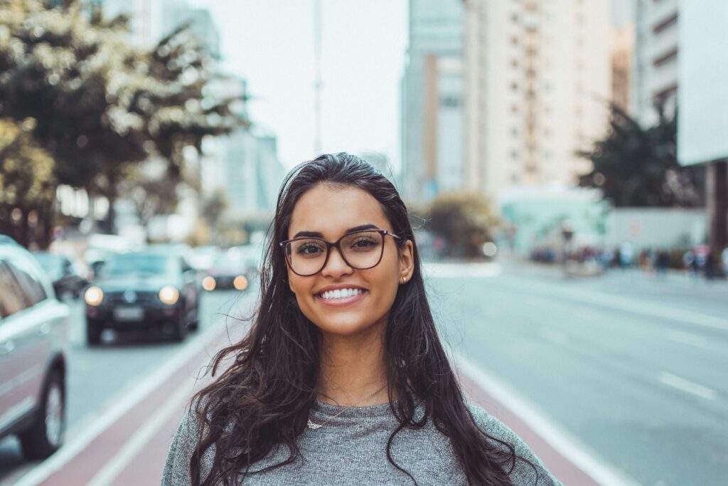 A young woman smiles on a city street representing someone who has benefited from Therapy for Women in NYC.