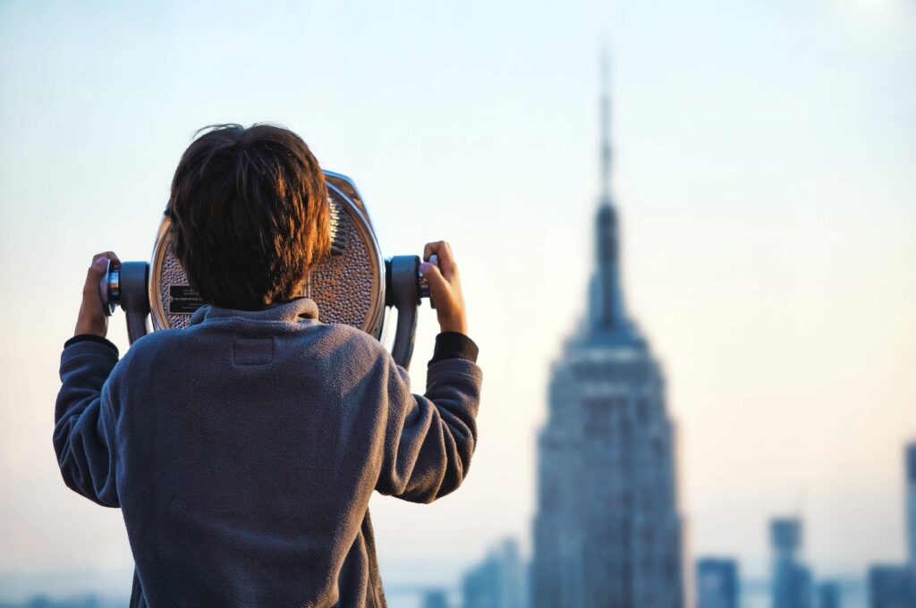 A child looks through a viewer at the New York City skyline. Get the support you need with Therapy for Special Needs Parenting in Manhattan, NY.