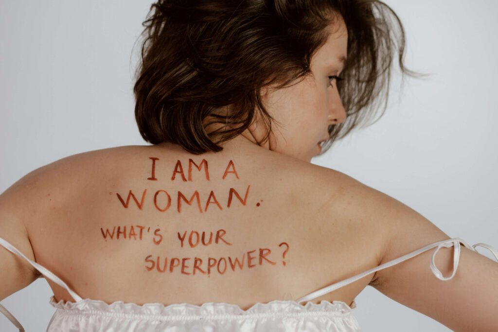 A woman with the words "I am a woman, what's your superpower?" on her back. Learn to live your truth with Therapy for Women's Mental Health in Manhattan, NY.