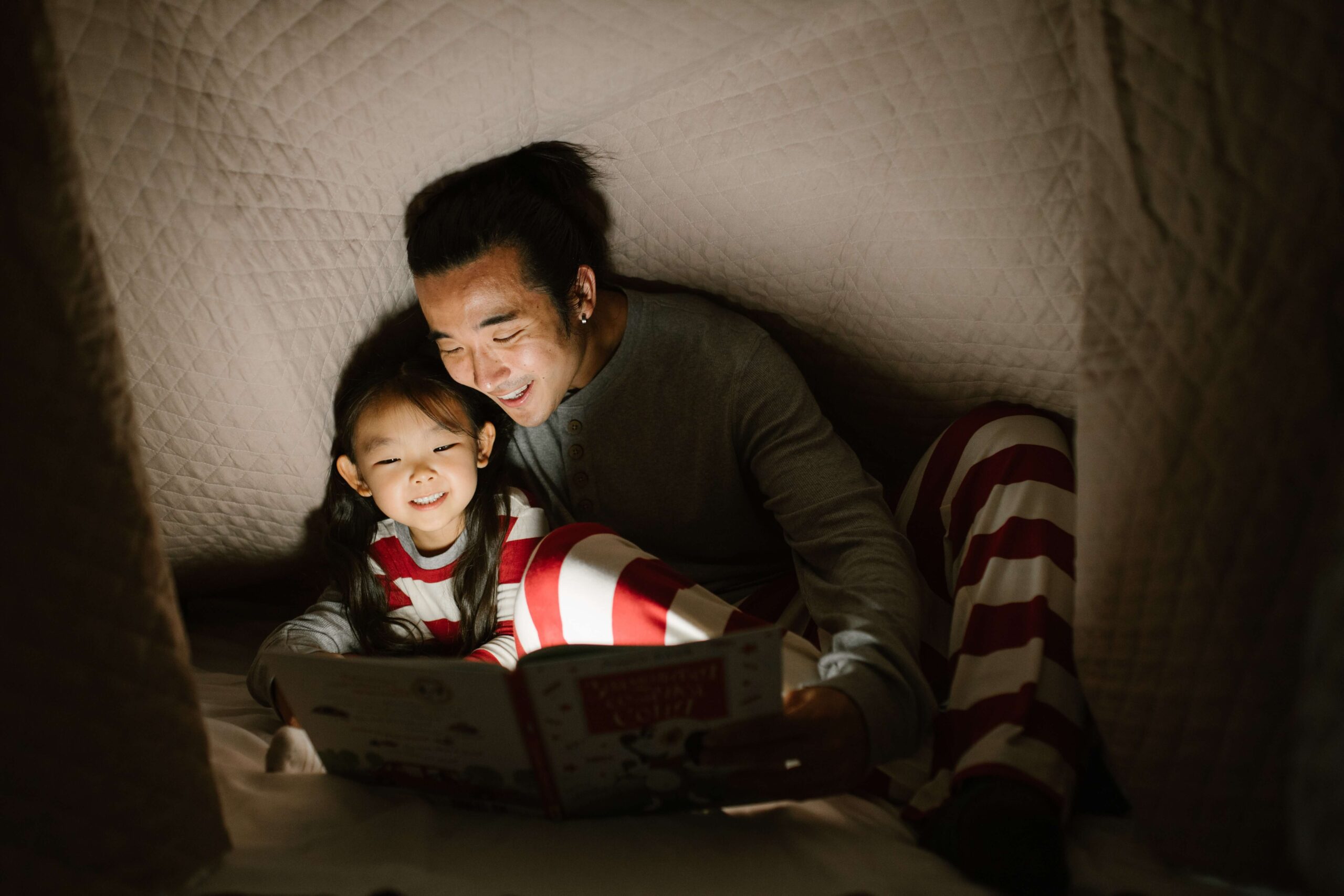 A father reads to his neurodiverse child representing someone who could benefit from the support of Therapy for Special Needs Parenting in NYC.