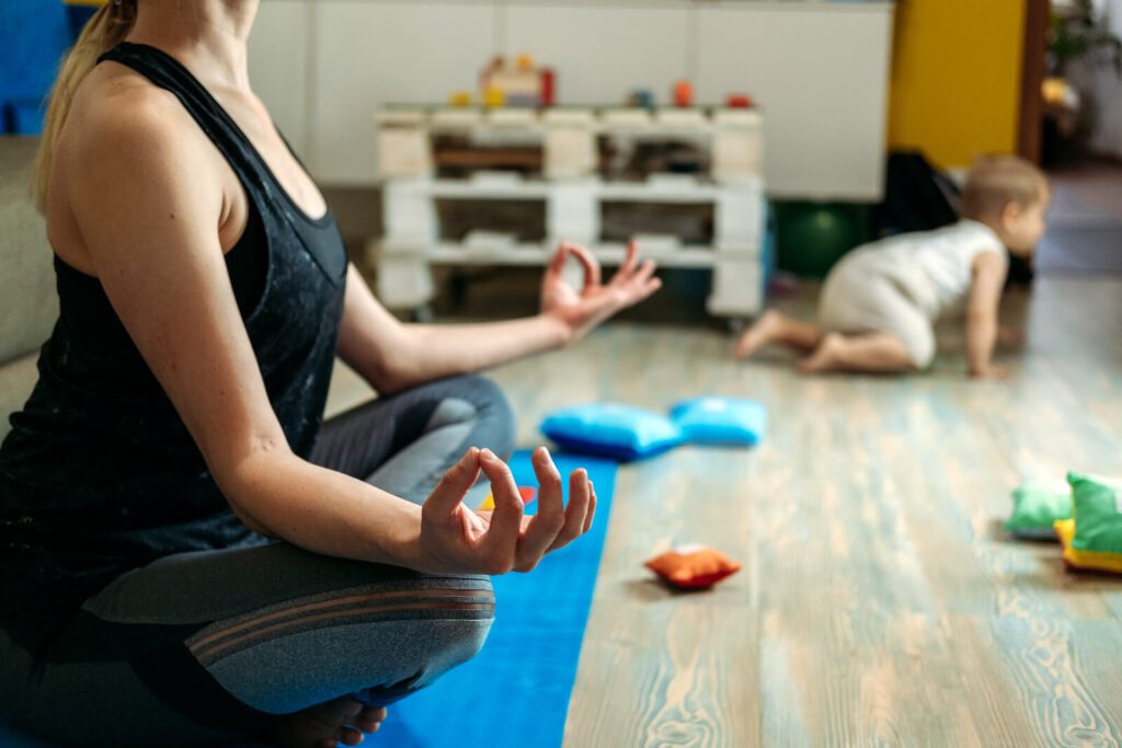 A mom sits on the floor with her child in the lotus position working to overcome anxiety. Therapy for Anxiety in Manhattan, NY is available to help.