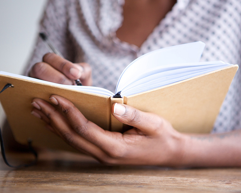 Person writing in a journal for CBT in NYC