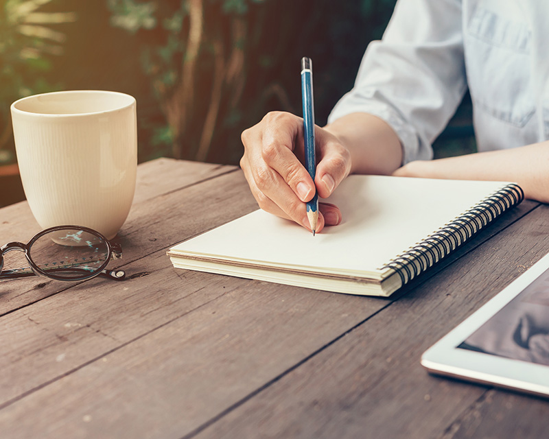 Woman writing in journal for self-esteem therapy in NYC