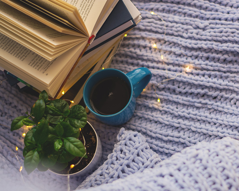 Books and cup of coffee with blanket